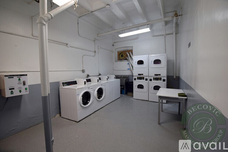 A laundry room with washing machines and dryers.