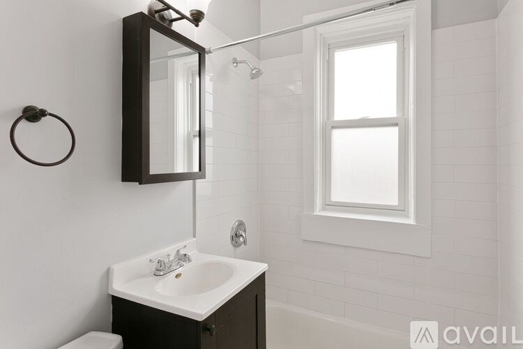 A bathroom with a white sink and a mirror above it.