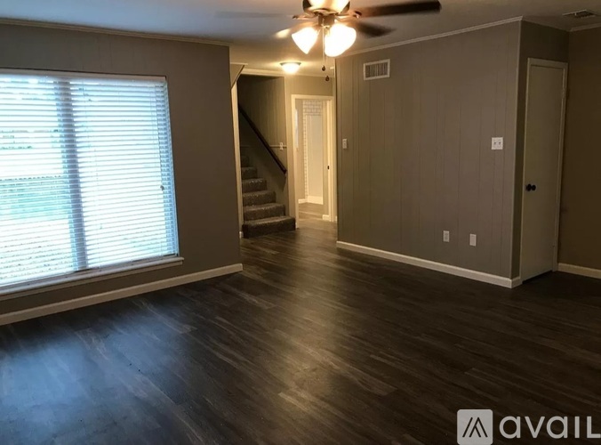 A room with wooden floors and a ceiling fan.
