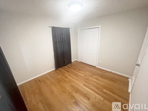 A room with wooden flooring and a white door.