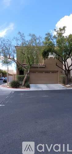 A house with a brown garage door and a tree in front.