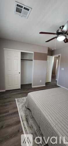 A bedroom with a bed and a ceiling fan.