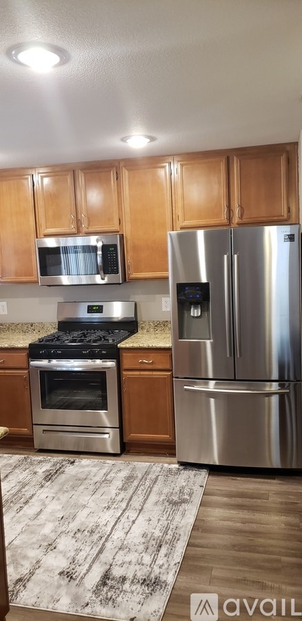 A kitchen with wooden cabinets and a stainless steel refrigerator.
