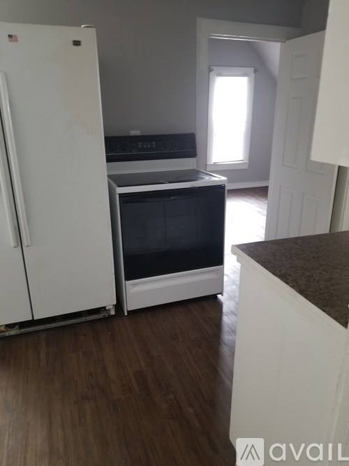 A kitchen with a white refrigerator and a black oven.