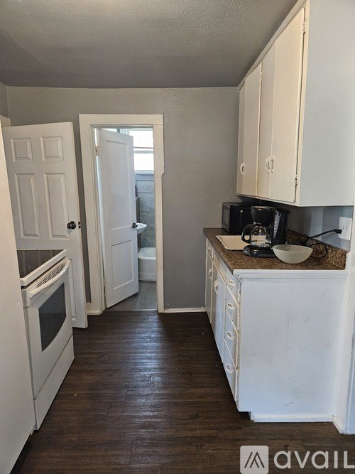 A kitchen with white appliances and cabinets.