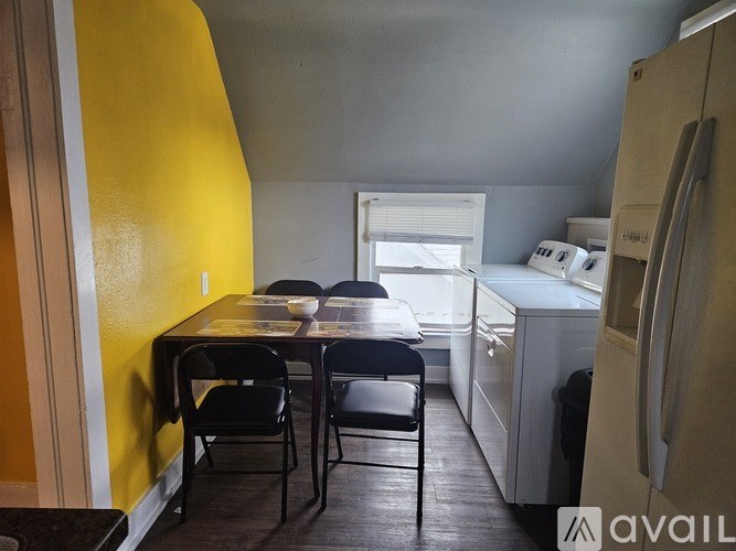 A kitchen with a table and chairs in front of a yellow wall.
