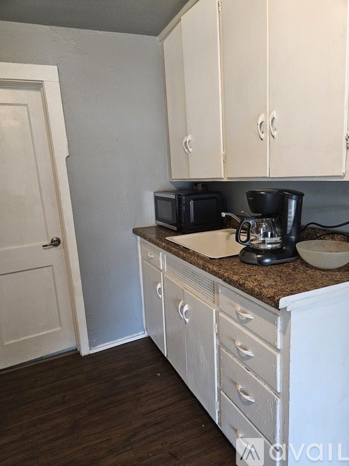 A kitchen with white cabinets and a granite countertop.