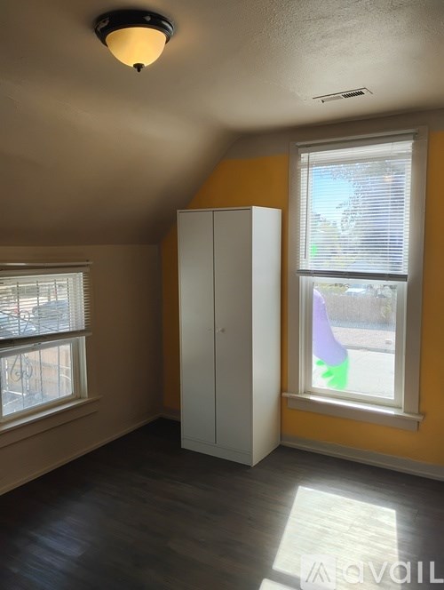 A bedroom with a bed, a chair, and a table.