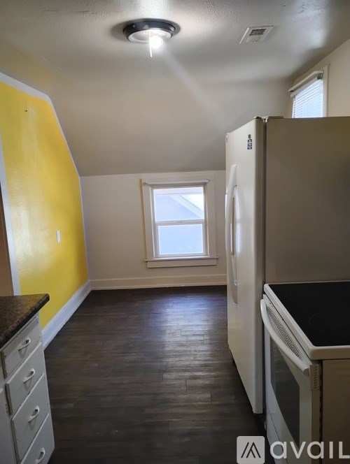 A room with a yellow wall and a painting on it.