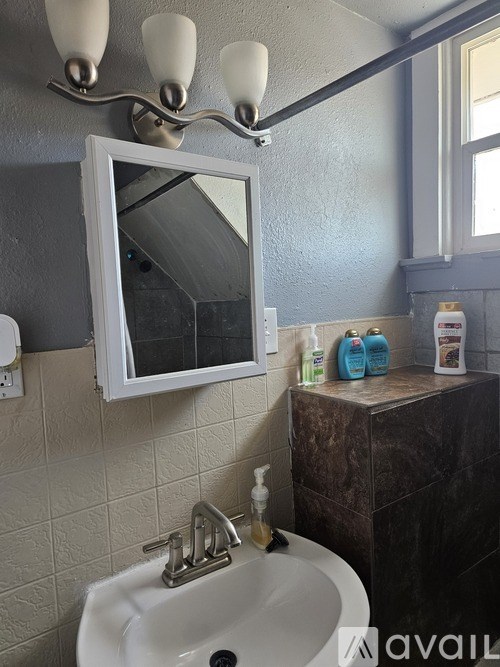 A bathroom with a white sink and a mirror above it.