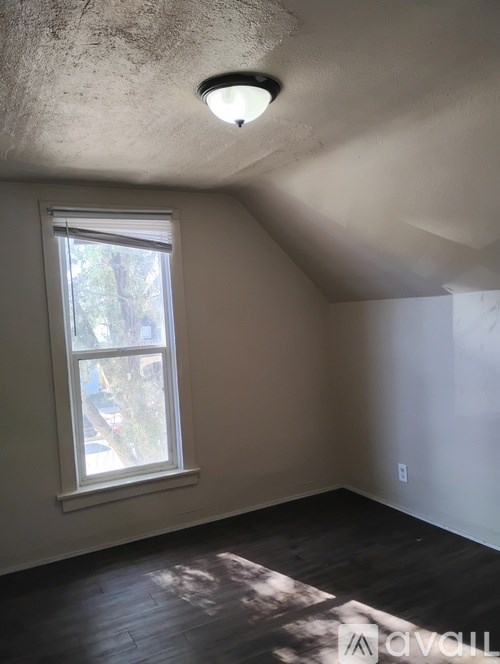 A room with a window and a ceiling light.
