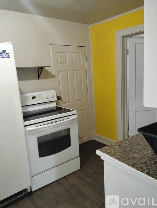 A kitchen with a white fridge and stove top oven.