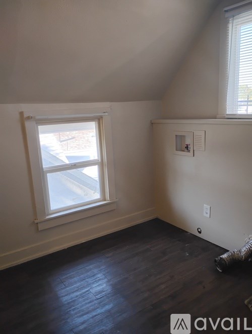 A room with a window and a wall socket.