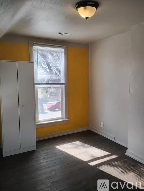 A room with a window and a cabinet.