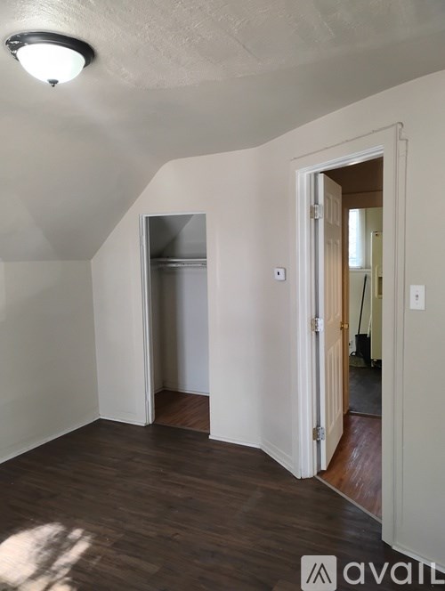 A room with a wooden floor and a white door.