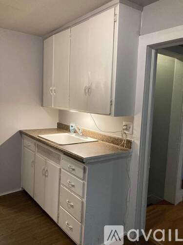 A kitchen with white cabinets and a countertop.