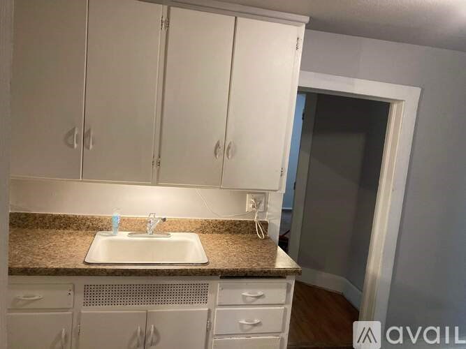 A kitchen with white cabinets and a granite countertop.