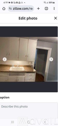 A kitchen with white cabinets and a brown countertop.