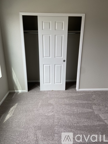 A white door is open to a dark room.