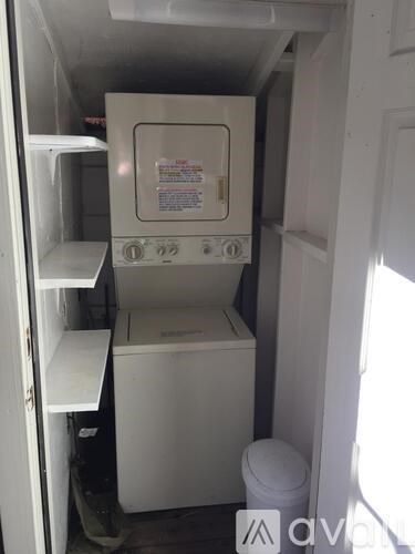 A small white kitchen with a toaster oven and a toilet.
