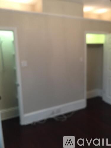 A room with a white wall and a door.