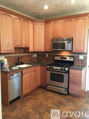 A kitchen with wooden cabinets and a black stove top oven.