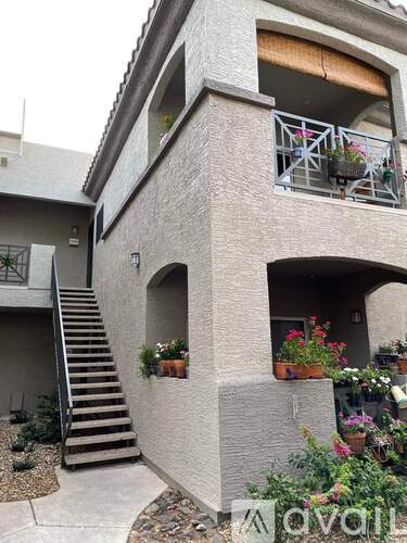 A small house with a balcony and flower pots.