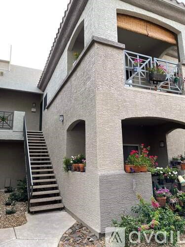 A small house with a balcony and flower pots.