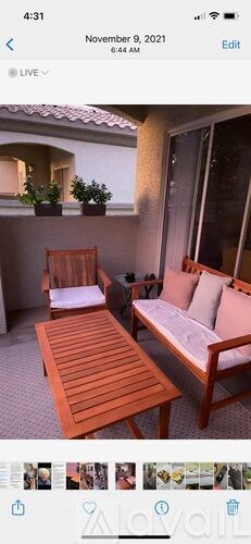 A wooden table and two chairs are set up on a patio.