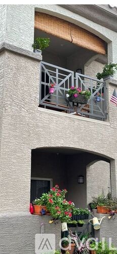 A balcony with a metal railing and potted plants.
