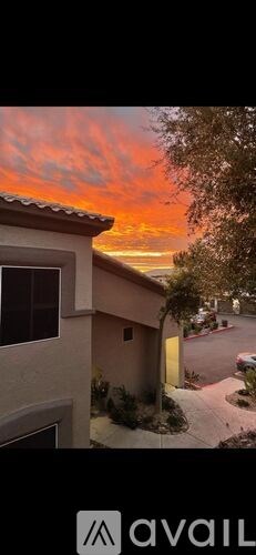 A house with a red roof and a tree in front of it.