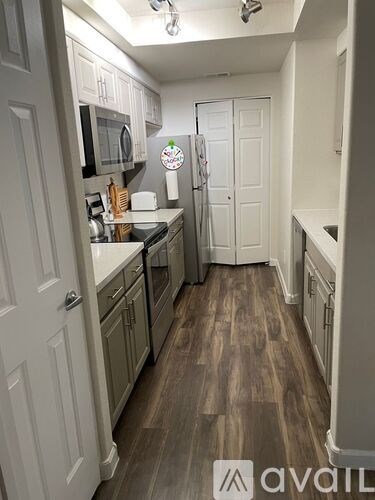 A kitchen with wood flooring and white walls.