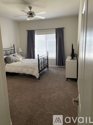 A bedroom with a bed, dresser, and television.