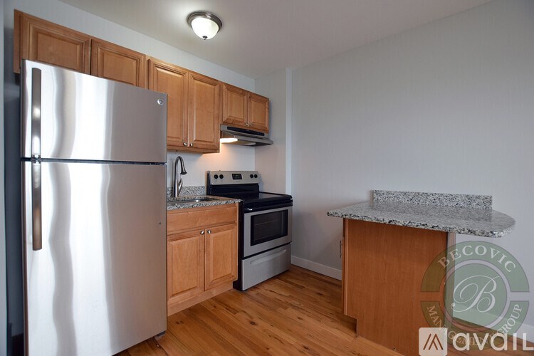A kitchen with a refrigerator, oven, and microwave.