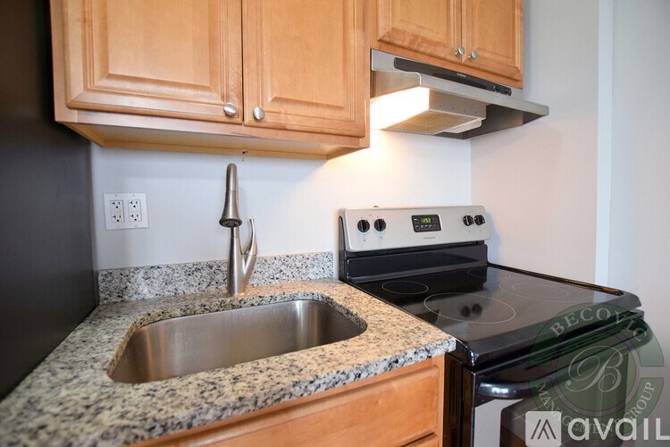A kitchen with a stove top oven and a granite counter top.