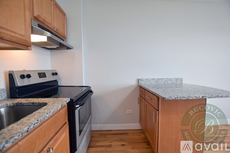 A kitchen with a stove, sink, and cabinets.