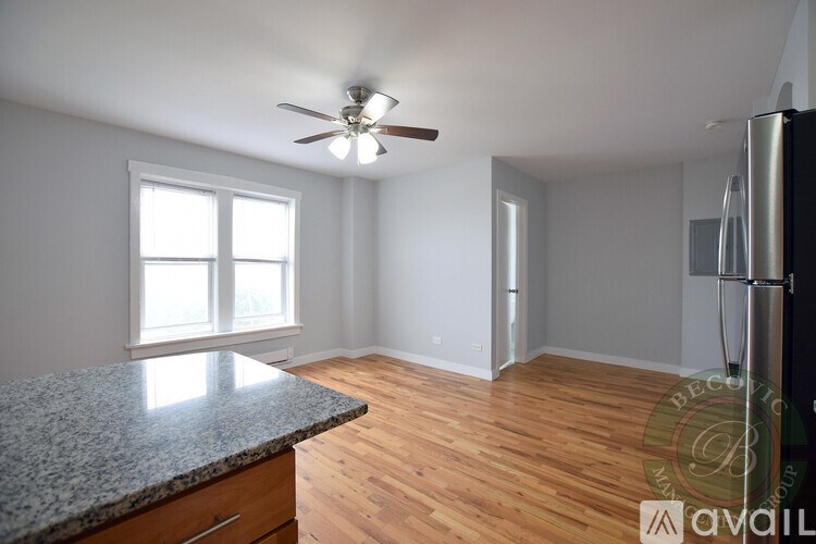 A kitchen with a granite countertop and a ceiling fan.