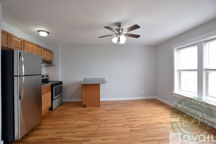 A kitchen with a refrigerator, microwave, and oven.