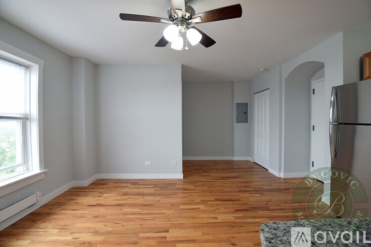 A room with wooden floors and a ceiling fan.