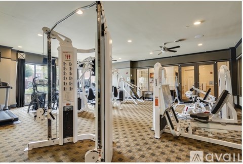 A gym with a variety of equipment including treadmills, weights, and a rowing machine.