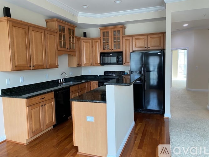 A kitchen with wooden cabinets and black appliances.