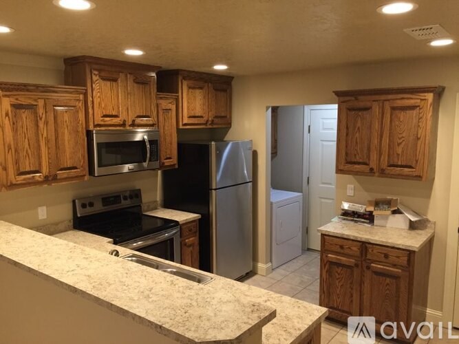 A kitchen with wooden cabinets and granite countertops.