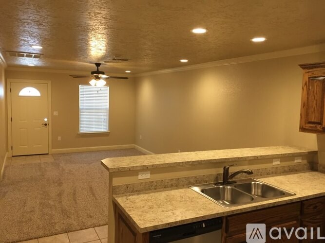 A kitchen with a sink and a fan on the ceiling.