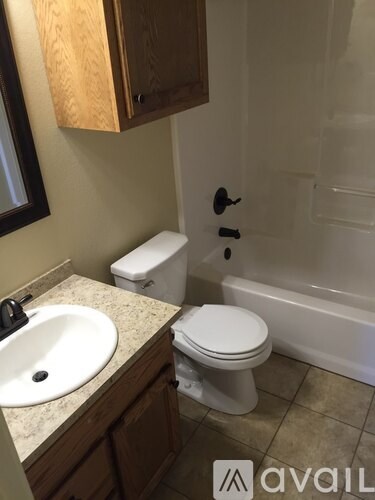 A bathroom with a toilet, sink, and tub.