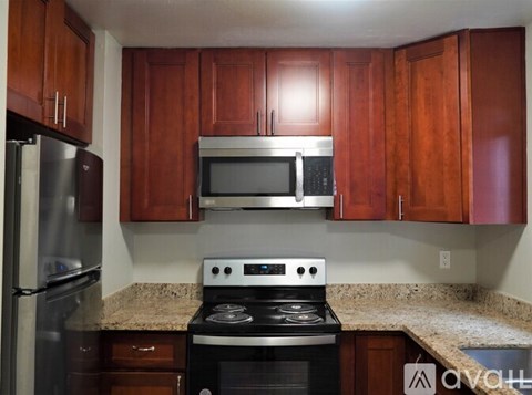 A kitchen with wooden cabinets and a stove top oven.