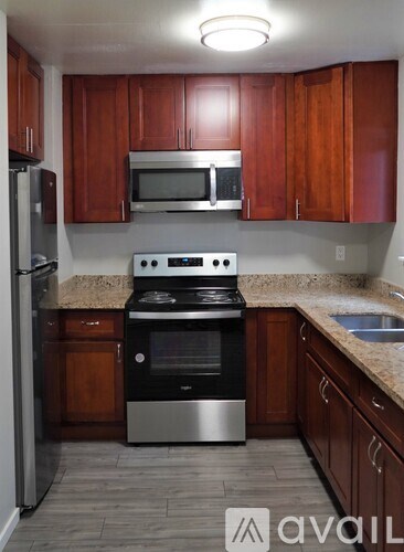 A kitchen with wooden cabinets and a black stove top oven.