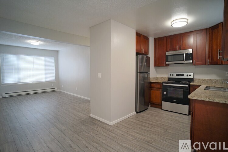 A kitchen with wooden cabinets and a refrigerator.