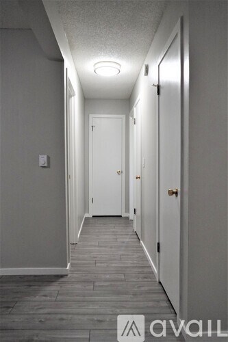 A long hallway with doors on both sides and a light on the ceiling.