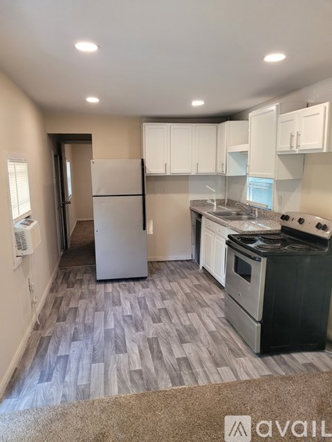 A kitchen with a white fridge, stove, and cabinets.