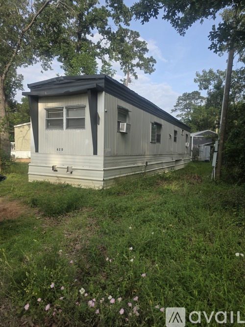 A mobile home with a grassy area in front of it.